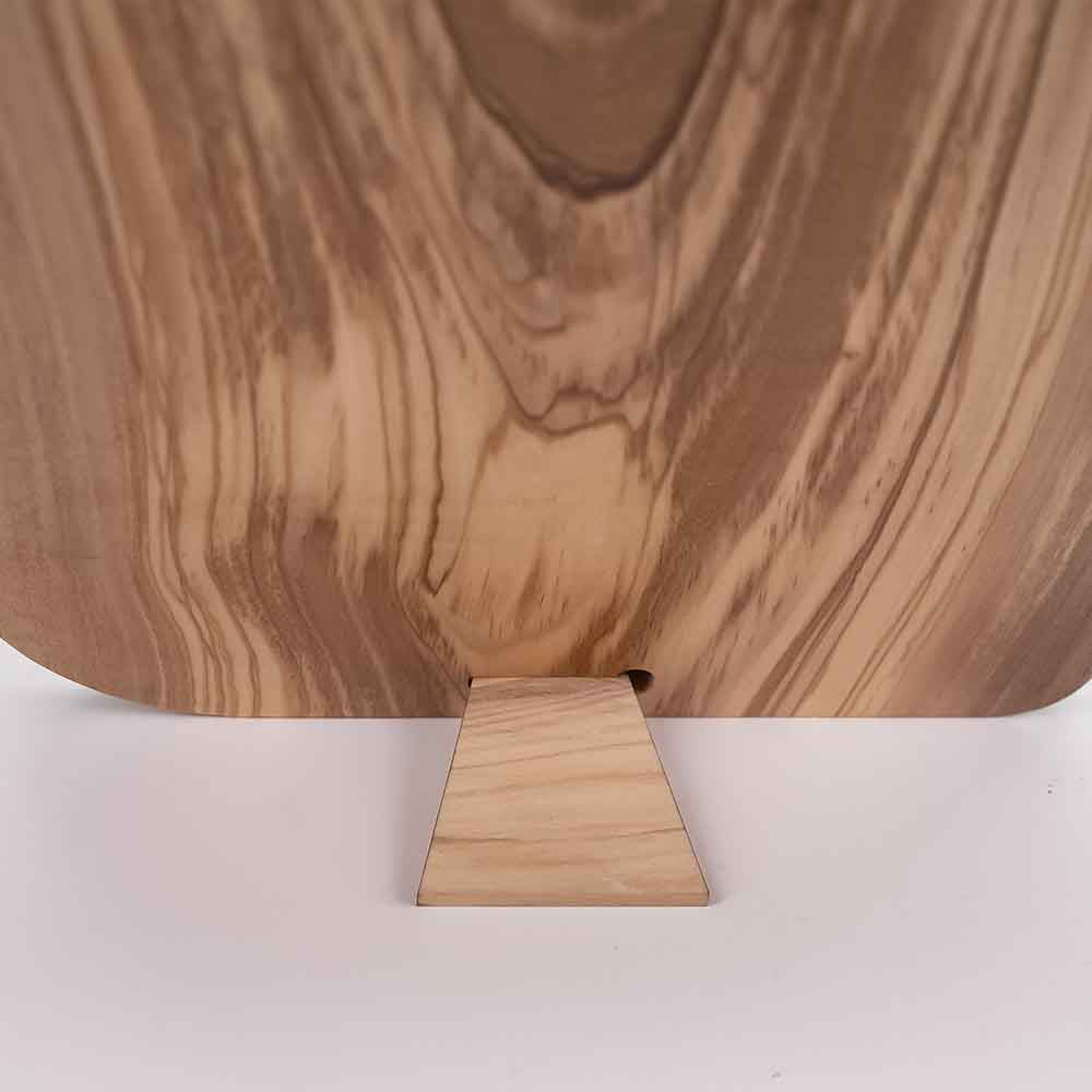 Dettaglio del piedino posteriore di un quadretto in legno d'ulivo, che consente il posizionamento su una superficie piana.