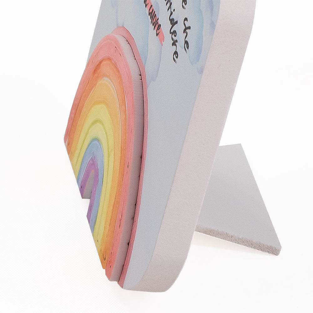 Vista ravvicinata del quadretto in legno con arcobaleno colorato in rilievo, evidenzia lo spessore degli elementi su sfondo decorato.