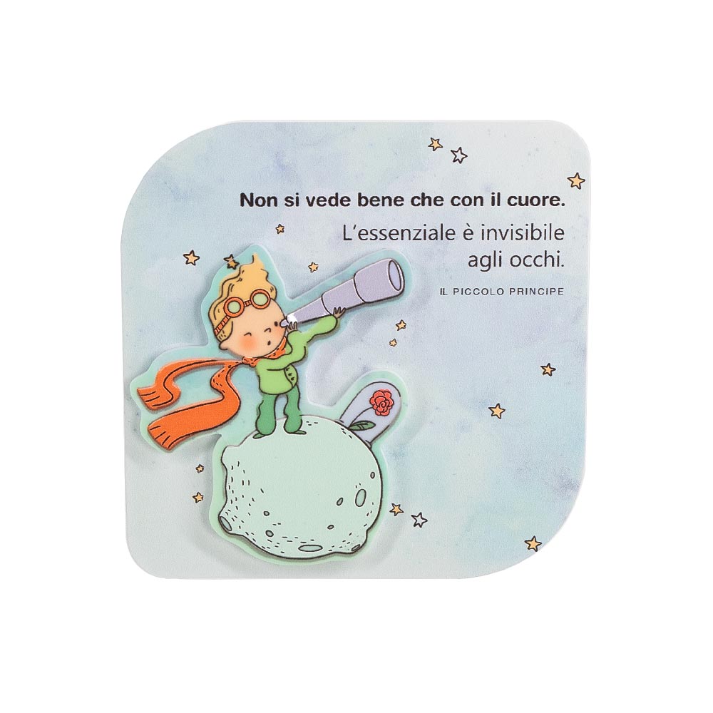 Quadretto in legno con personaggio del Piccolo Principe in rilievo su pianeta con fiore, frase “L’essenziale è invisibile agli occhi” su sfondo celeste.