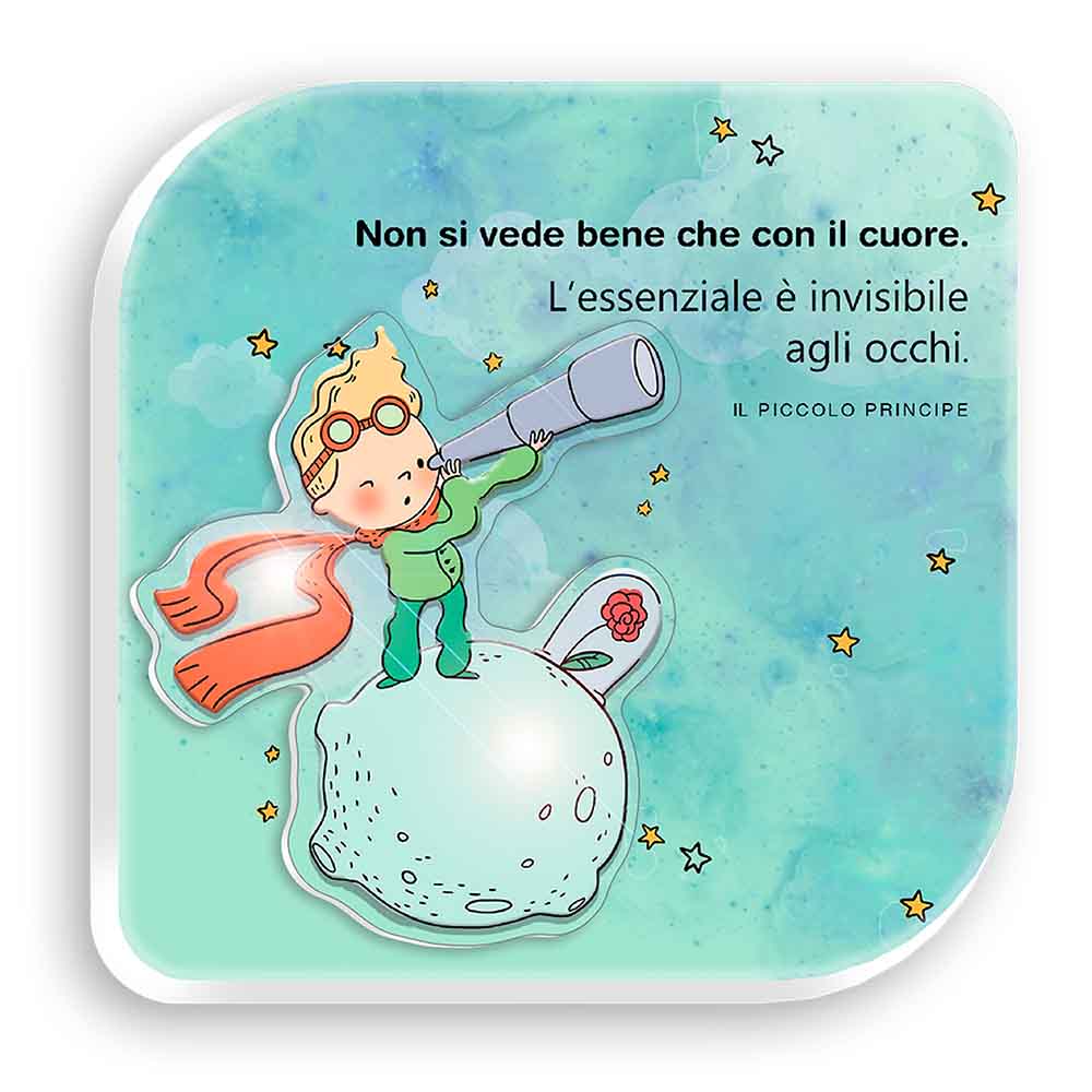 Quadretto in legno con personaggio del Piccolo Principe in rilievo su pianeta con fiore, frase “L’essenziale è invisibile agli occhi” su sfondo celeste.