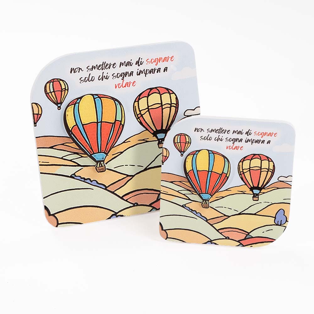 Coppia di quadretti in legno con paesaggio collinare e mongolfiere in rilievo, frase motivazionale “Non smettere mai di sognare” in alto.
