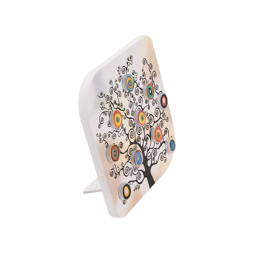 Vista laterale di quadretto in legno con supporto, mostra decorazioni in rilievo su albero ornamentale a spirali con elementi concentrici colorati.