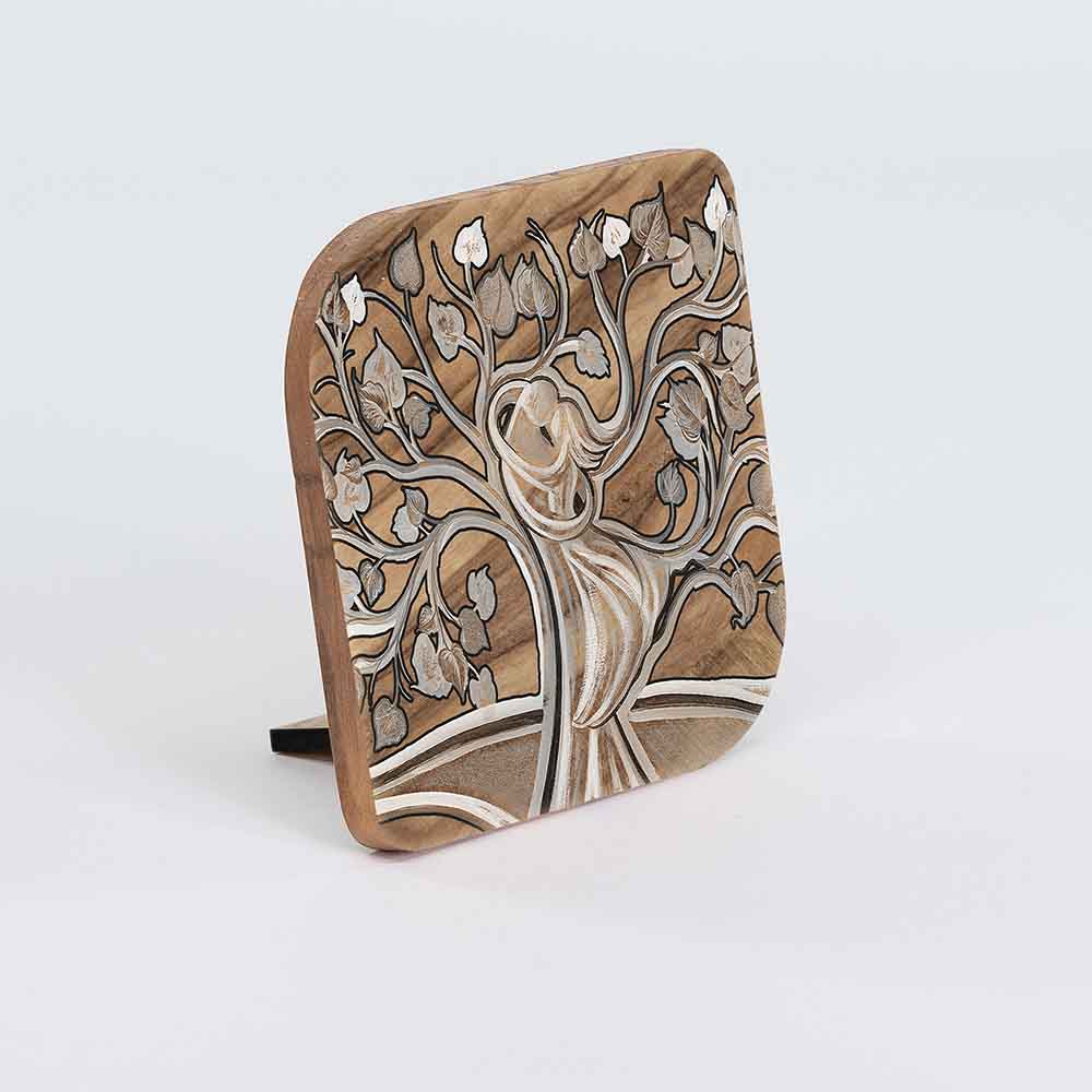 Quadretto in legno d'ulivo con decorazione artistica di un albero stilizzato, rami intrecciati e figure umane armonizzate nel tronco in un abbraccio.