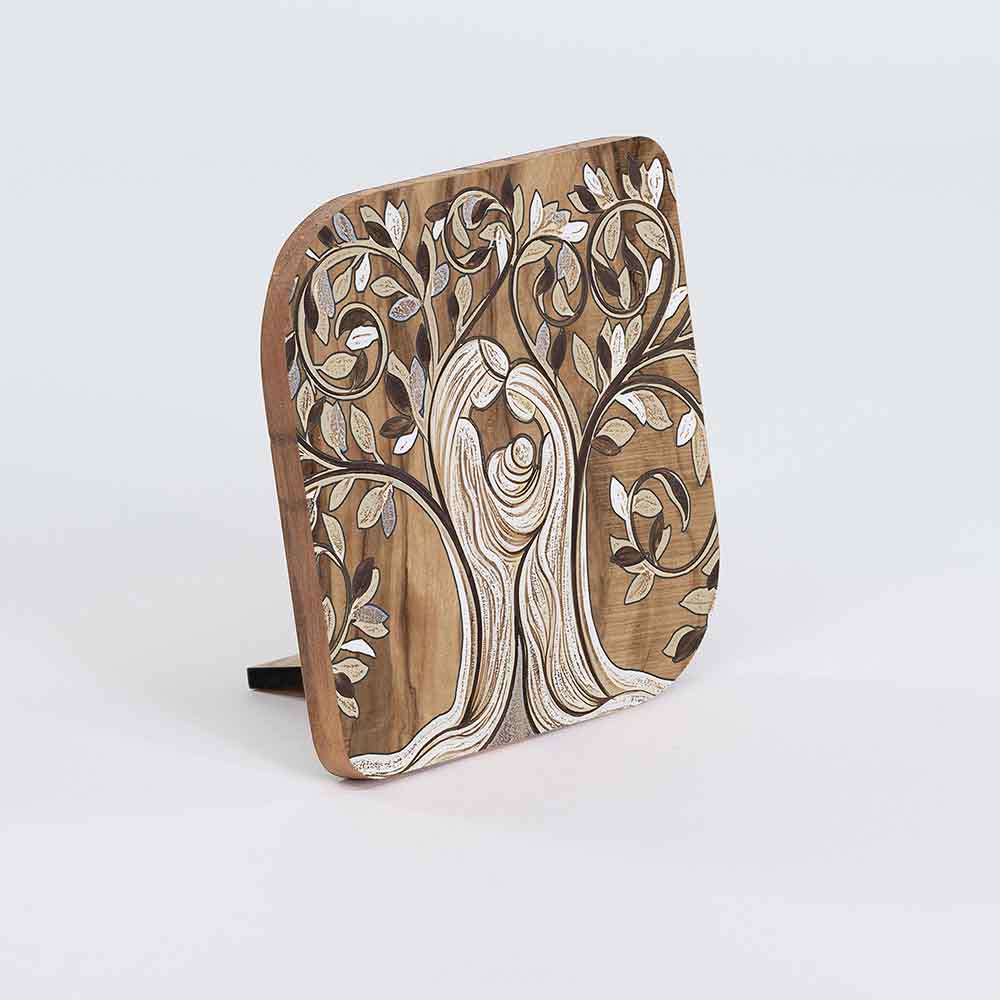 Quadretto in legno d'ulivo con decoro di un albero con sacra famiglia, visto lateralmente per evidenziare la profondità.