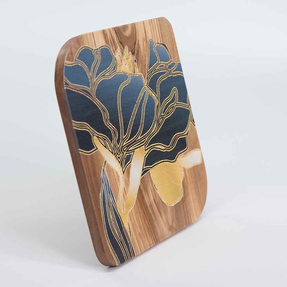 Vista laterale di un quadretto in legno d'ulivo con fiori dorati, mostrando la profondità e il bordo lavorato.