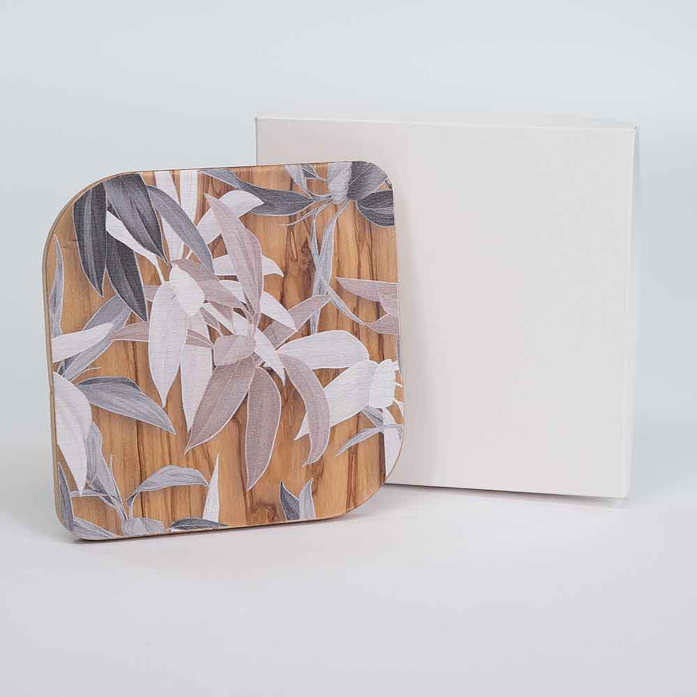 Quadretto in legno d'ulivo con decoro di foglie miste, presentato vicino alla sua confezione per una visione completa.