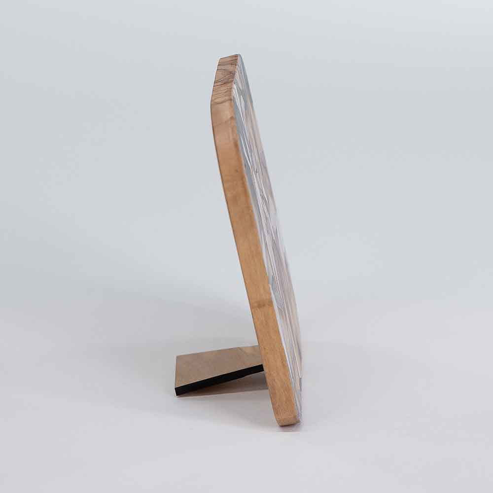 Vista laterale di un quadretto in legno d'ulivo di piccole dimensioni, evidenziando i dettagli del bordo.