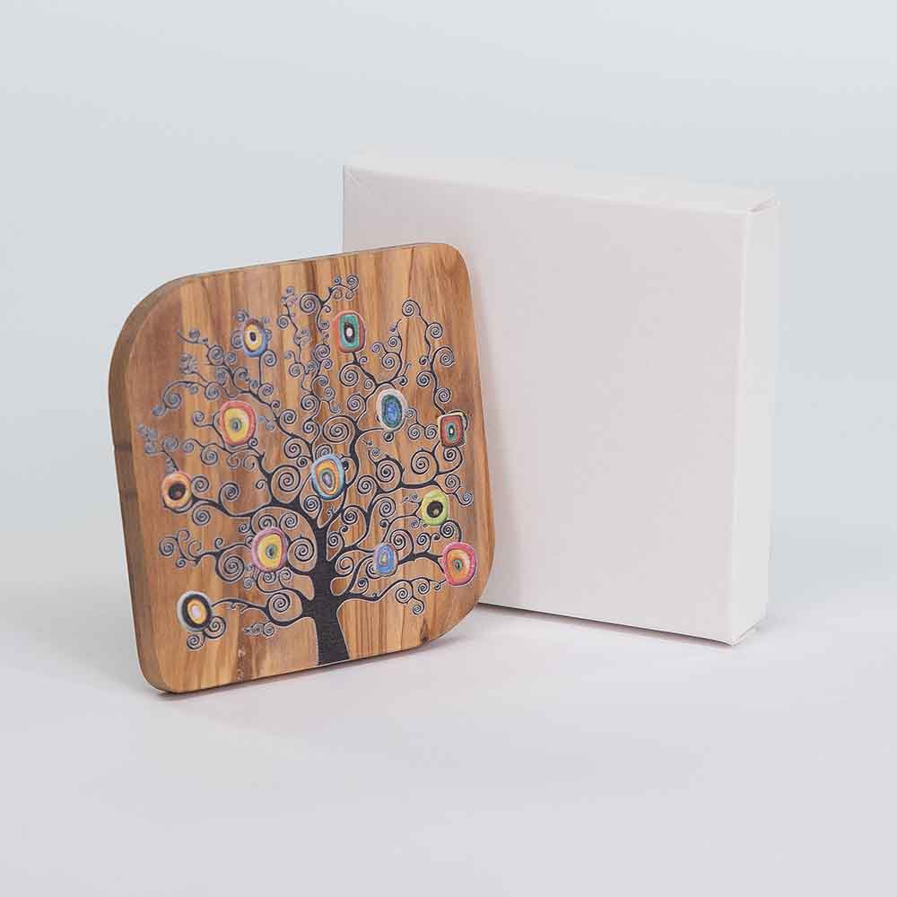 Quadretto in legno d'ulivo rappresentate l’albero della vita, affiancato a lui è presente la sua confezione, per un effetto visivo elegante.