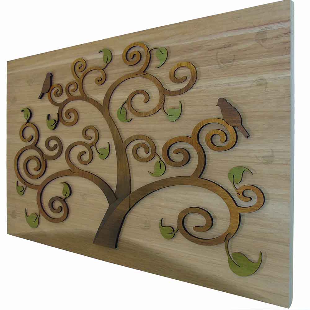 Vista laterale di quadro in legno a rilievo con albero della vita, che ne evidenzia la profondità tra l’albero e il pannello retrostante.