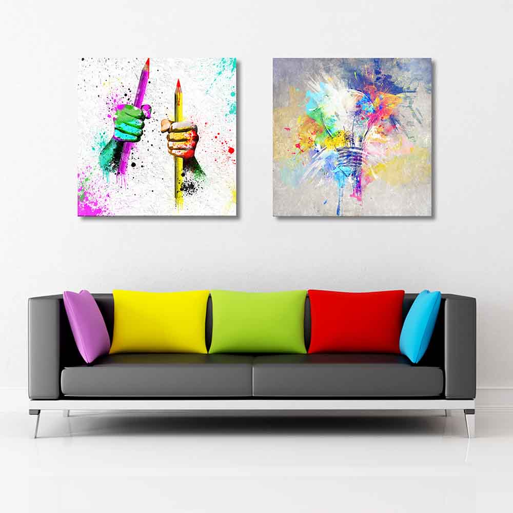 Due quadri astratti su tela sul muro: uno con mani colorate che stringono matite, l'altro con una lampadina esplosiva di colori, simbolo di creatività.