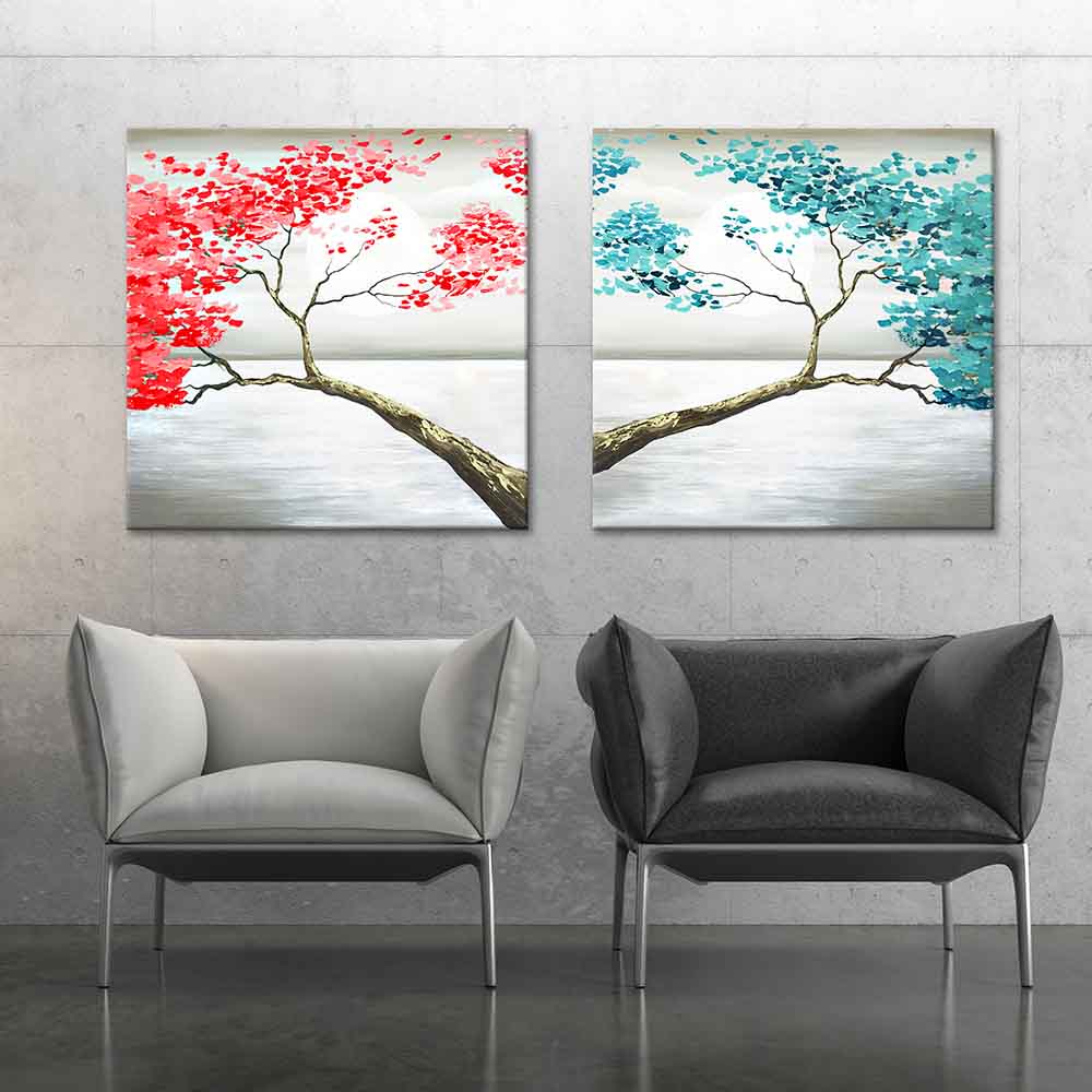Set di due quadri su tela con rami d'albero speculari, uno con foglie azzurre e uno con foglie rosse, creando armonia cromatica.