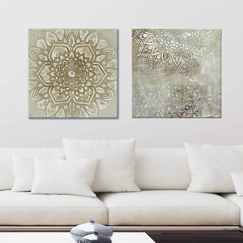 Coppia di quadri su tela con mandala beige e marrone posizionato sopra un divano bianco, perfetto per arricchire l’arredo con un tocco di eleganza.