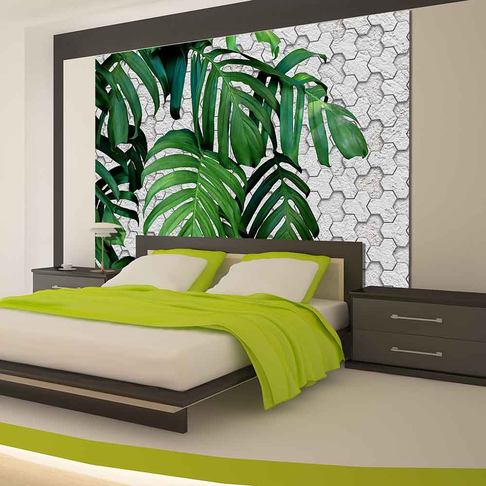 Quadro su tela grande con foglie tropicali verdi su sfondo chiaro, decorando una camera con atmosfera naturale.