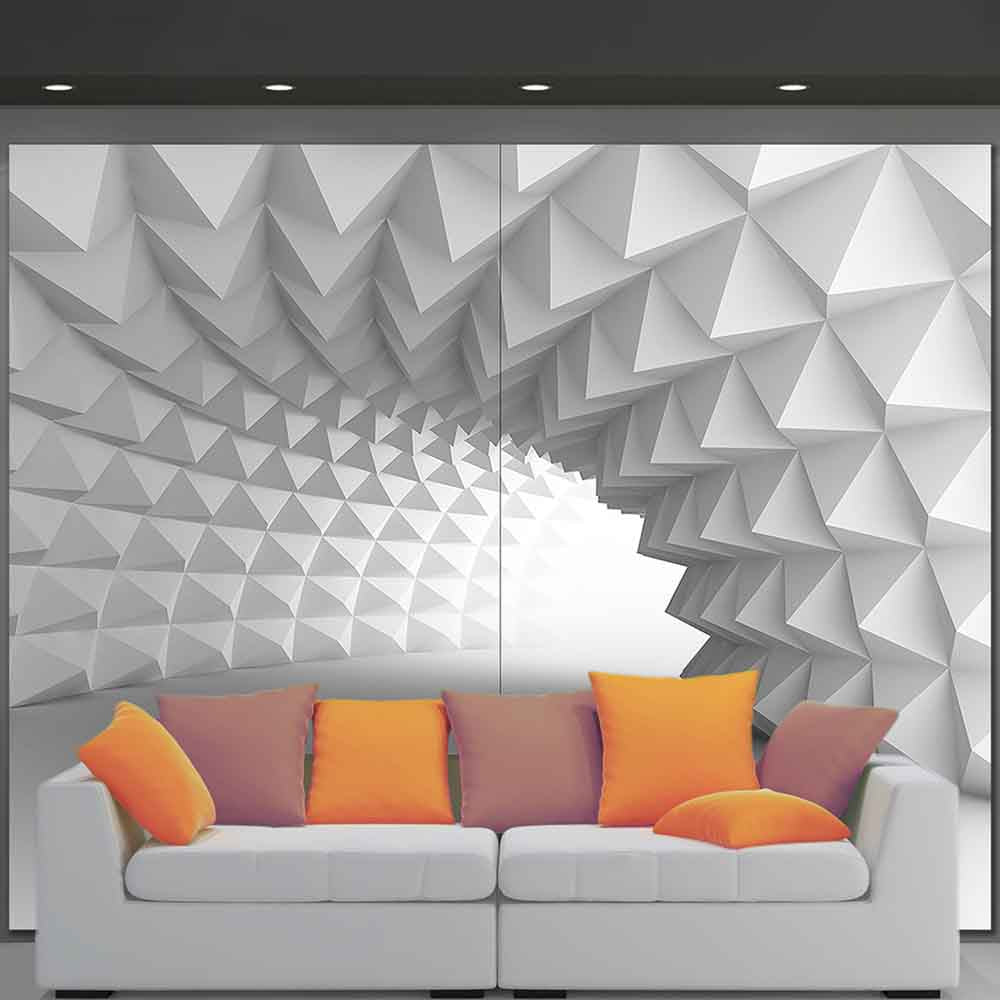 Quadro su tela grande con design geometrico tridimensionale, collocato sopra un divano in un ambiente contemporaneo.