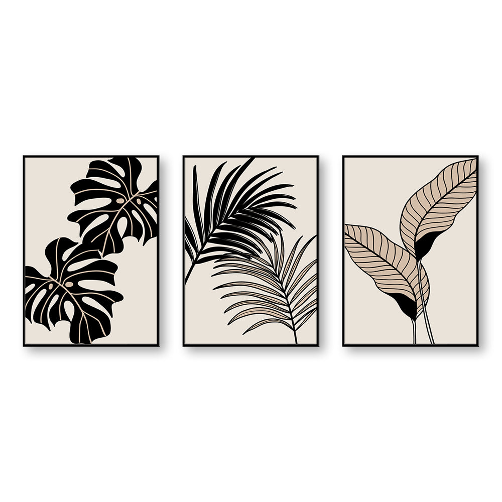 Set di 3 quadri affiancati orizzontalmente: monstera nera, fronde di palma e foglie beige a righe su sfondo neutro.