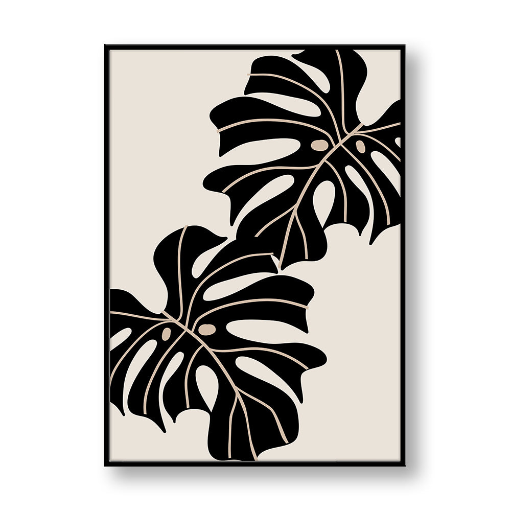 Quadro su pannello verticale con cornice nera: due foglie di monstera nere con venature beige, disposte in diagonale su fondo neutro.