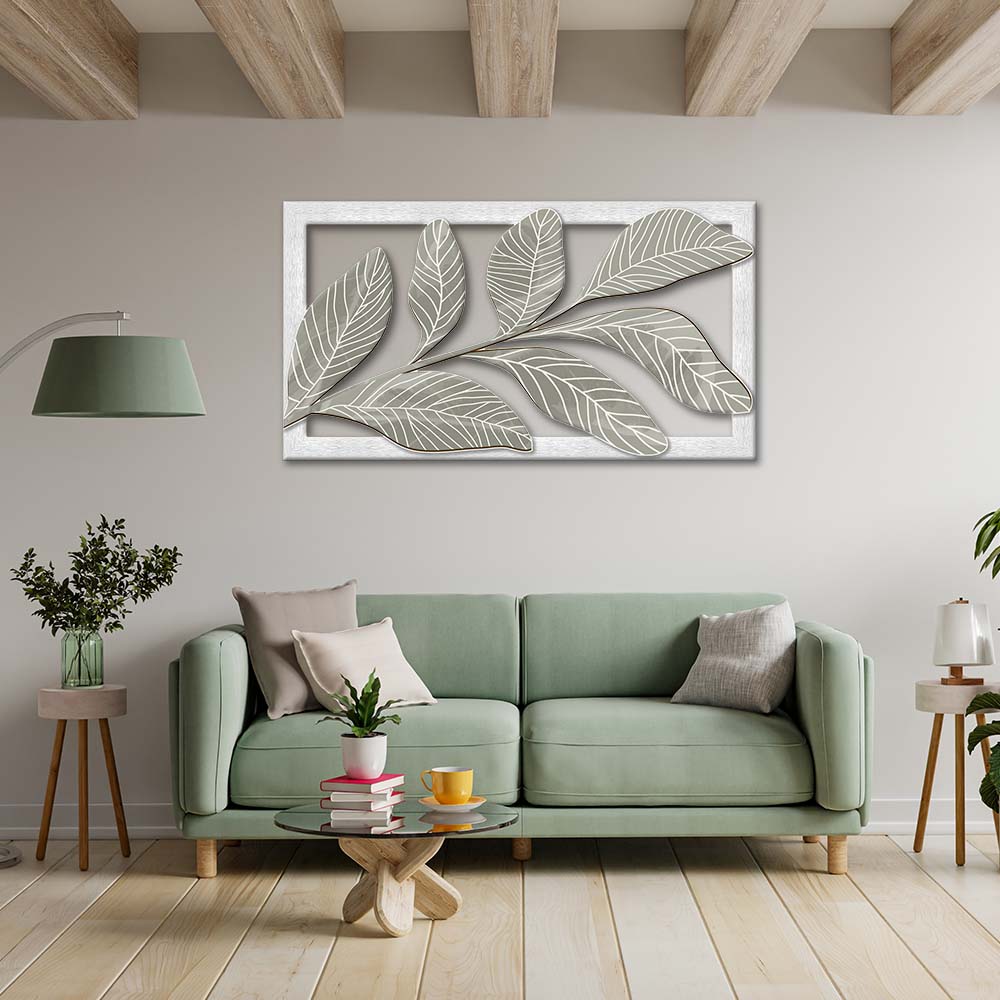 Quadro in legno intagliato appeso in salotto, vista frontale: ramo con grandi foglie grigio-verdi a rilievo e venature bianche