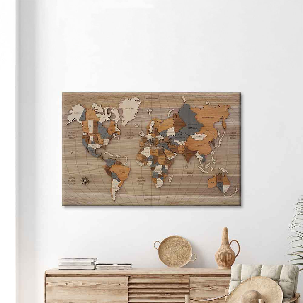 Quadro in legno a rilievo composto da una mappa del mondo tridimensionale, montato su un pannello in legno e appeso sul muro bianco.