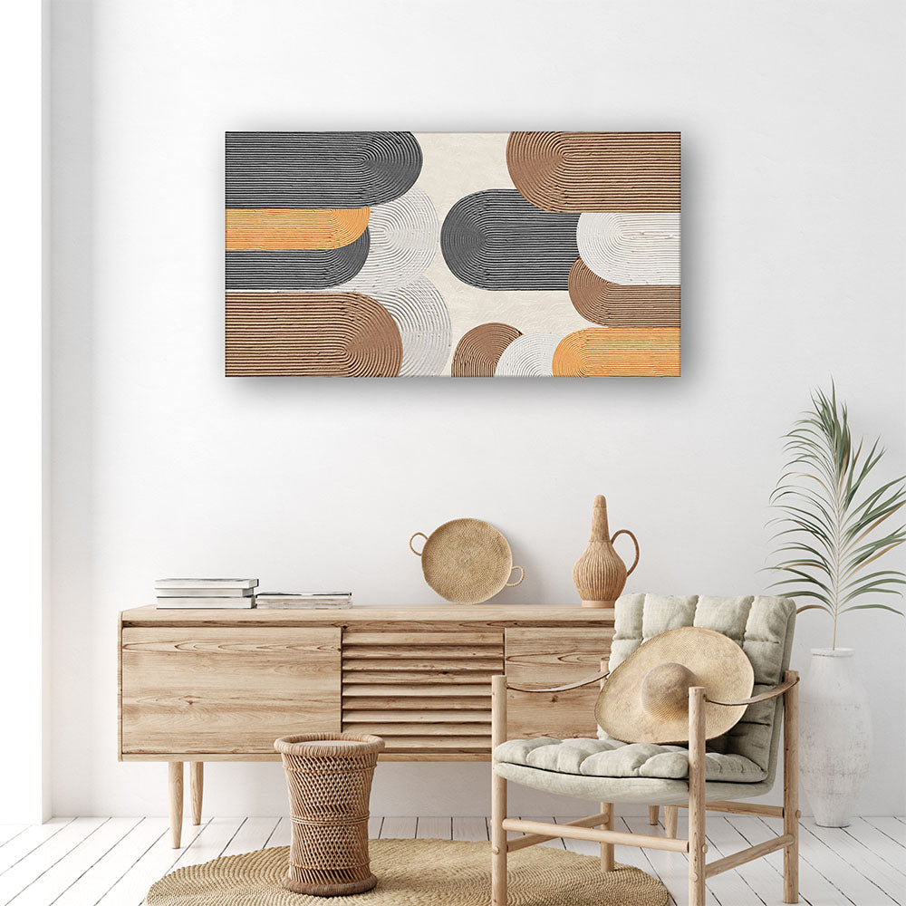 Quadro materico con archi a rilievo nei toni antracite, terracotta e arancio, appeso su parete bianca sopra madia in legno in soggiorno boho.