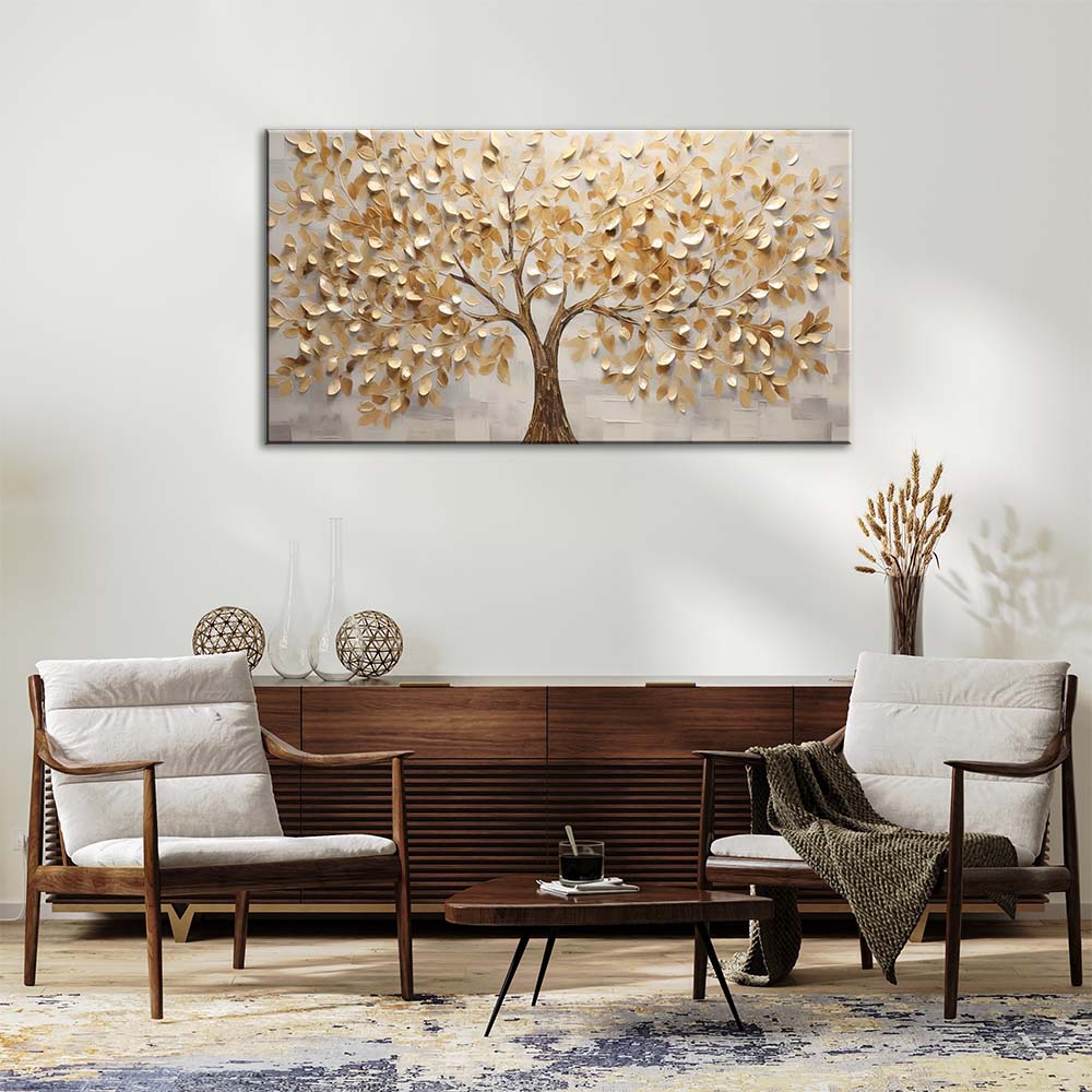 Quadro materico con albero dalle foglie dorate in rilievo, appeso su parete chiara sopra credenza in legno in soggiorno con poltrone e tavolino.