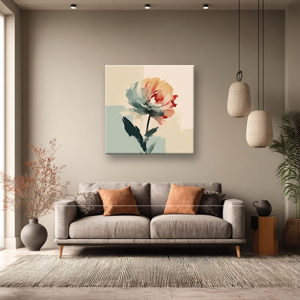 Soggiorno elegante con divano grigio e cuscini ocra; sulla parete un quadro su tela con fiore astratto verde acqua e arancione su sfondo chiaro.