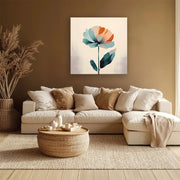 Soggiorno moderno in toni caldi con divano chiaro e tavolino intrecciato; sulla parete un quadro su tela con fiore stilizzato blu e arancione.