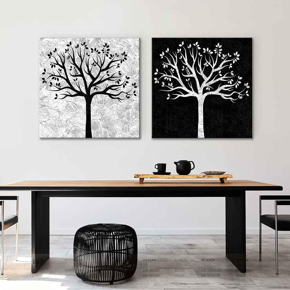Coppia di quadri su tela con albero bianco su nero e nero su bianco, appesi su una parete chiara in una camera moderna, dal design simmetrico.