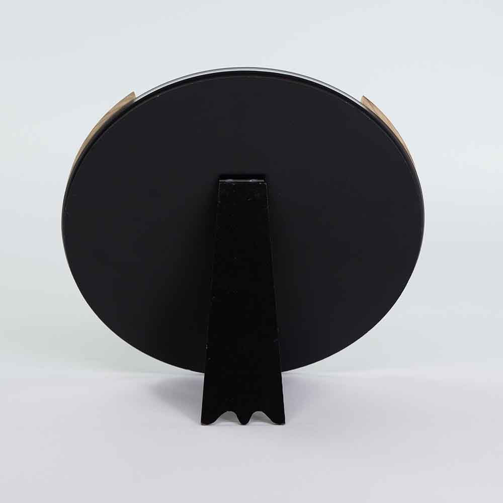Retro dello specchio rotondo in ulivo con superficie nera opaca e supporto centrale per un posizionamento sicuro.