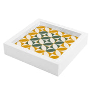 Svuotatasche bianco decorato con forme geometriche verdi e ocra, disposte in moduli regolari, in vista laterale.