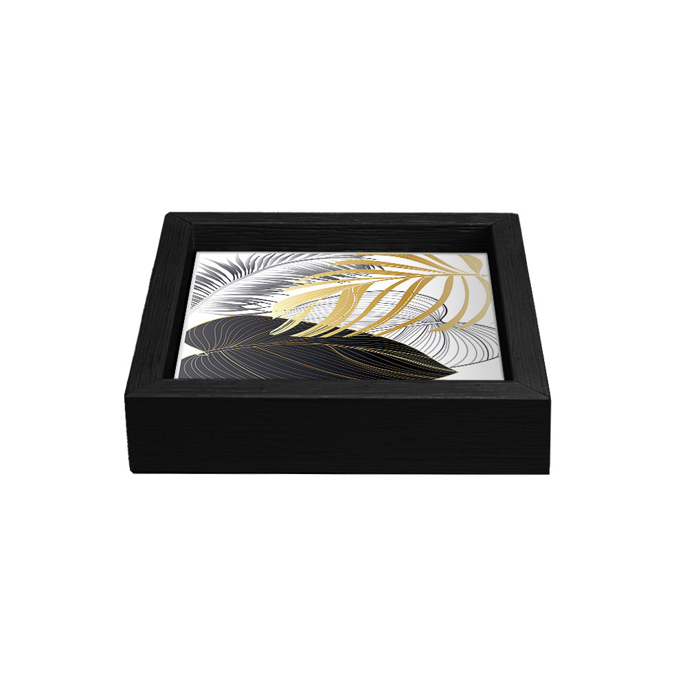 Svuotatasche nero con fondo bianco decorato da foglie stilizzate nere, dorate e argentate, disposte in elegante sovrapposizione.