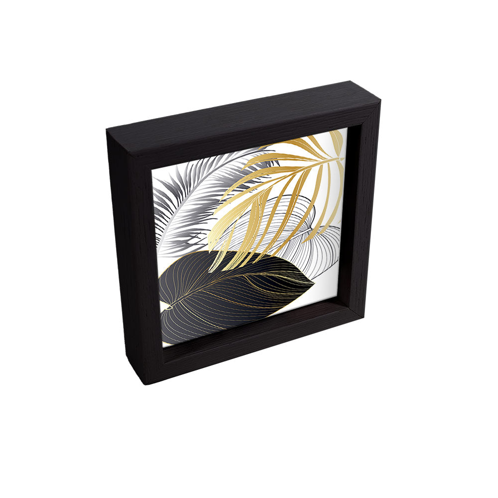 Svuotatasche nero elegante, con interno illustrato da foglie sovrapposte in oro lucido, nero e argento su sfondo neutro.