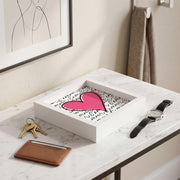 Svuotatasche in legno bianco con cuore rosa e scritta "l'amour" su fondo bianco, con chiavi dorate, portacarte e orologio su marmo