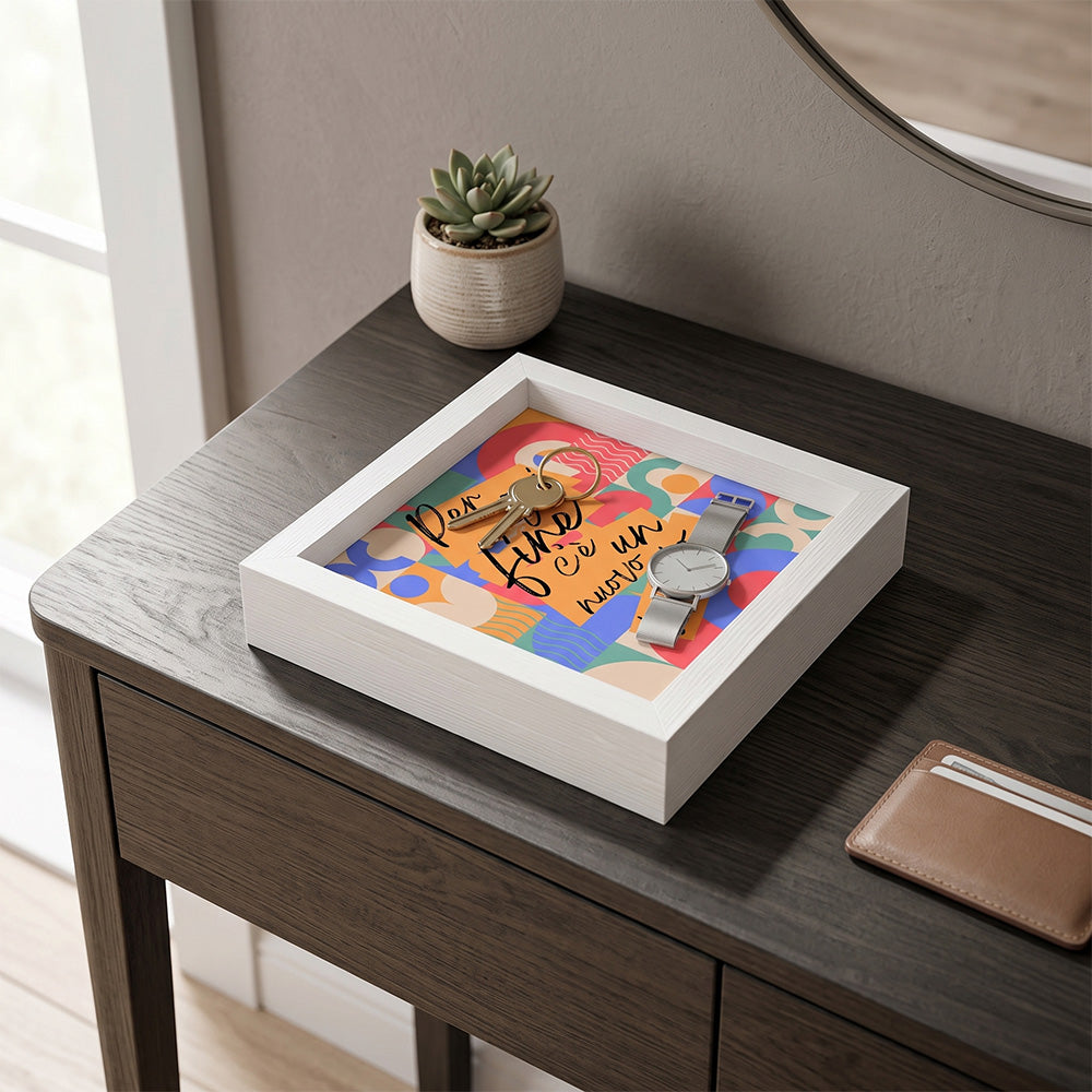 Svuotatasche in legno bianco con decoro geometrico multicolore e frase motivazionale, con chiavi e orologio argento su tavolo scuro