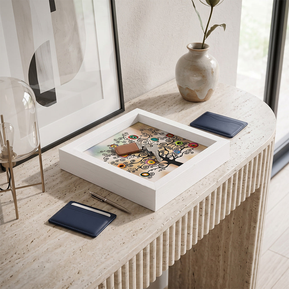Svuotatasche in legno bianco con albero della vita colorato stile Klimt, con chiavi e portacarte blu su consolle in travertino