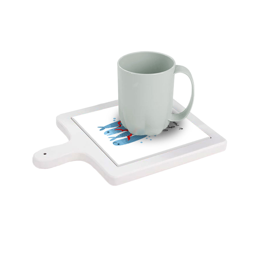 Tagliere in ceramica bianca orizzontale con tazza sopra, decoro con pesci blu e frase “La felicità è reale solo se condivisa”.