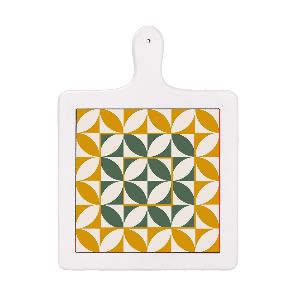 Tagliere verticale in ceramica bianca con decoro geometrico simmetrico in verde scuro e ocra su base bianca.