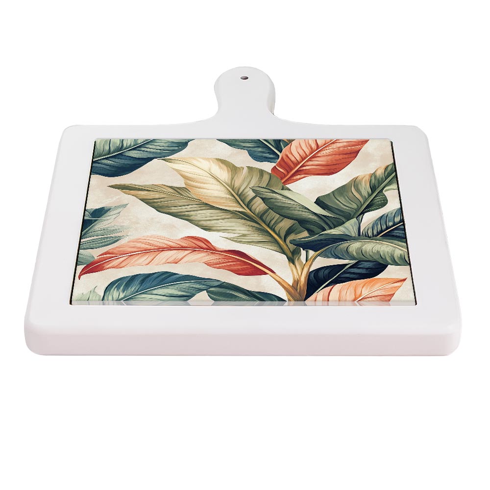 Tagliere orizzontale in ceramica bianca con decoro botanico tropicale: foglie verdi, arancio e beige su fondo avorio.