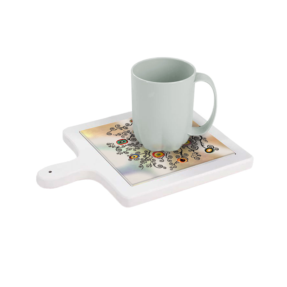 Tagliere bianco in ceramica visto dall’alto con tazza appoggiata e decoro albero dai rami neri e frutti colorati.