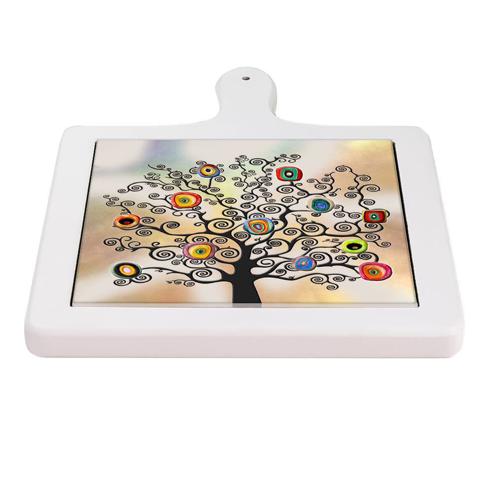 Tagliere in ceramica posizionato frontalmente, con albero nero dai rami a spirale e frutti geometrici multicolore.