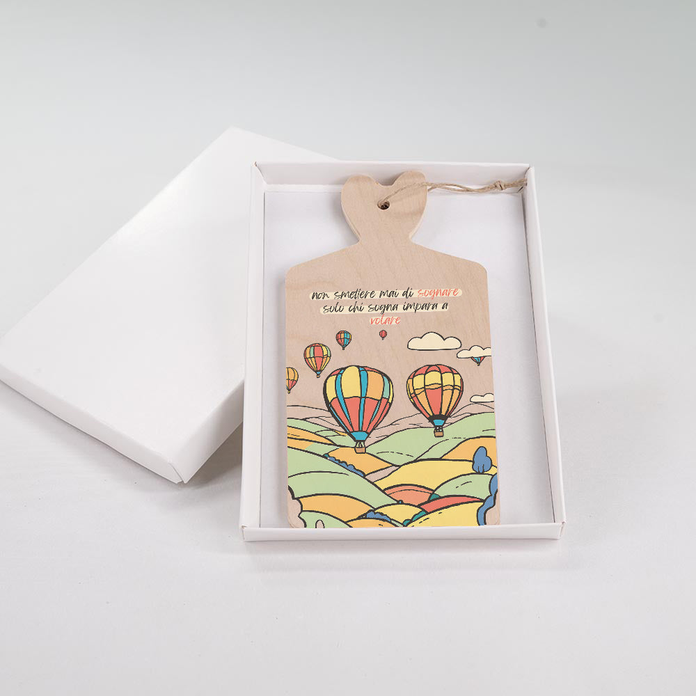 Tagliere decorativo in legno con paesaggio e mongolfiere, inserito in scatola regalo bianca, manico a cuore con cordino.