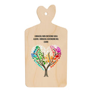 Tagliere in legno a forma di cuore con frase “I miracoli non crescono sugli alberi, i miracoli avvengono nel cuore” e illustrazione di due alberi che formano un cuore colorato.