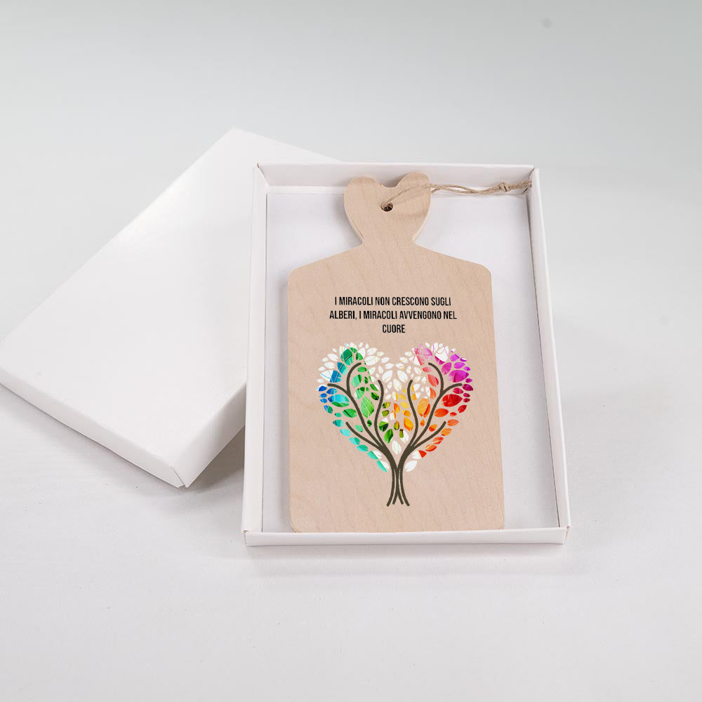 Tagliere in legno con albero della vita a forma di cuore multicolore con foglie arcobaleno e frase motivazionale sui miracoli del cuore.