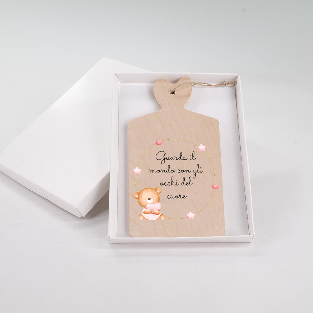 Tagliere in legno con orsetto che abbraccia un cuore rosa, corona circolare di stelle e cuori, frase "Guarda il mondo con gli occhi del cuore".