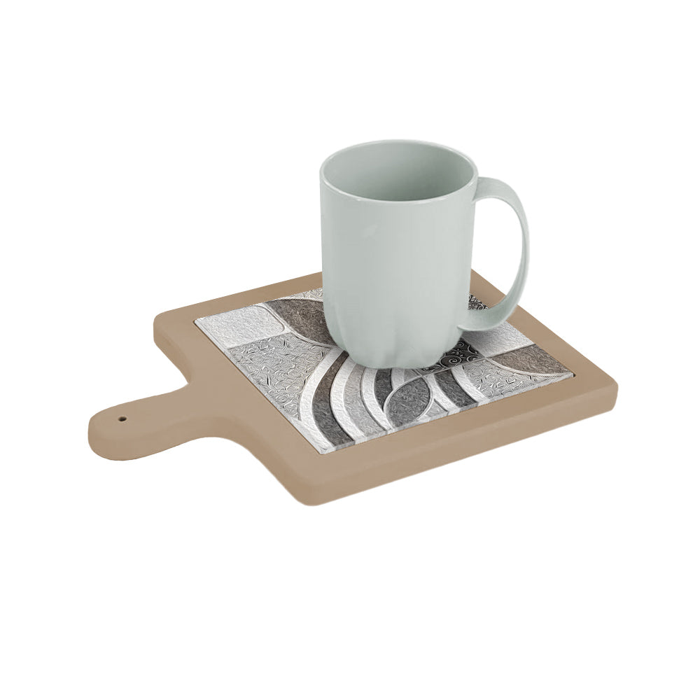 Tagliere in ceramica beige con tazza appoggiata sopra, decorato con motivi a foglia, curve e texture a rilievo nei toni neutri.