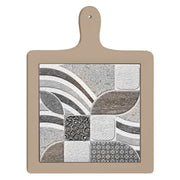 Tagliere in ceramica posizionato frontalmente in verticale, con manico e mosaico centrale dai motivi curvilinei e fogliati neutri.